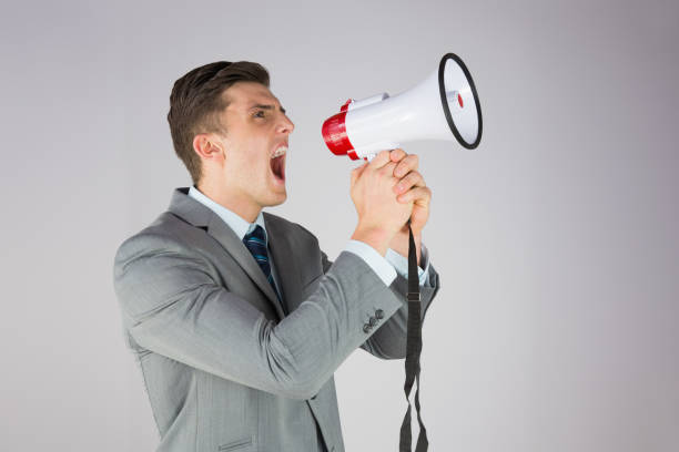istock Angry businessman shouting through megaphone 816094272