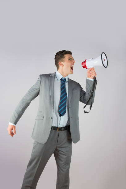 istock Angry businessman shouting through megaphone 816096340