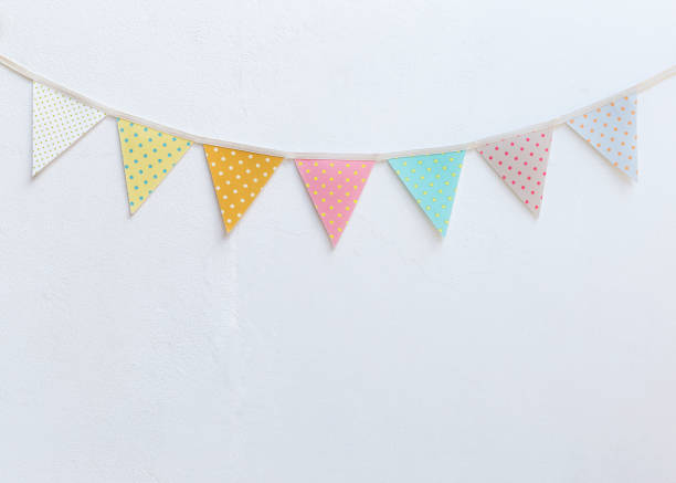 Design vintage fabric party flag over white cement wall texture background, outdoor day light