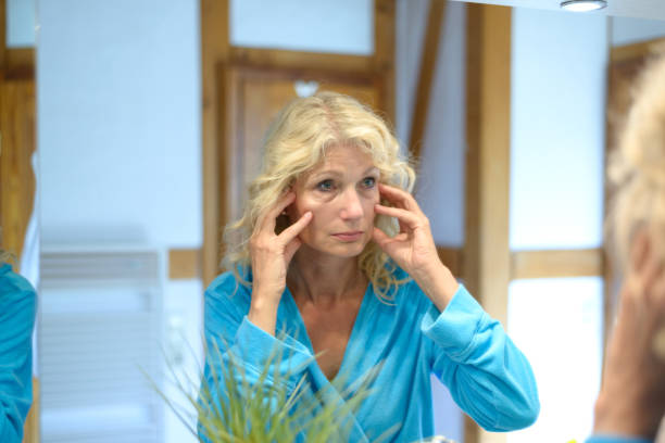 istock Senior woman checking her wrinkles in a mirror 816116878