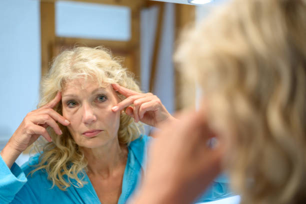 istock Senior woman checking her wrinkles in a mirror 816119348