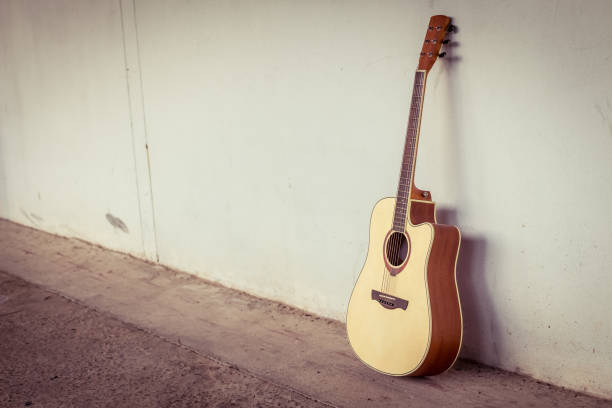 istock acoustic guitar on gray wall background with shadow edge.vintage tone. 816122694