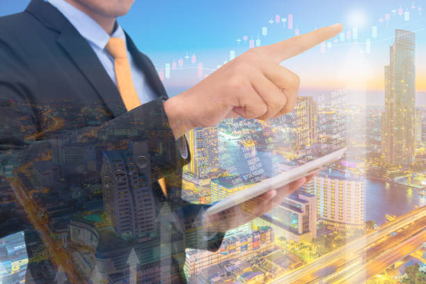 istock business man Trading concept using the tablet with financial graph on cityscape background, Double exposure style 816139184