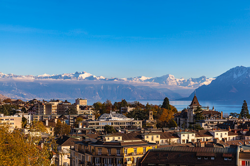 Cityscape of Lausanne with the snow covered Alps and the Leman lake in the background, Canton of Vaud, Switzerland