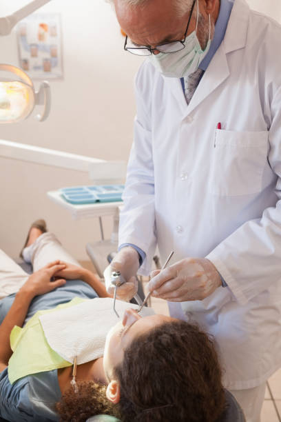 istock Dentist examining a patients teeth in the dentists chair 816152738