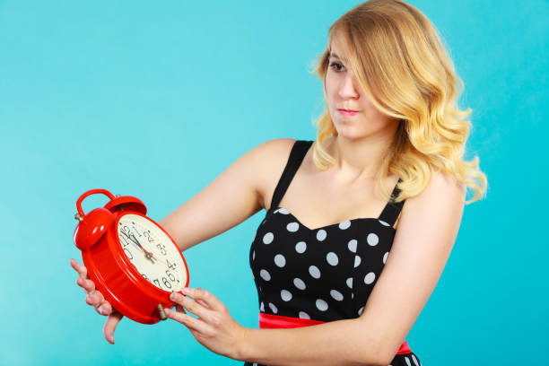 istock Shocked girl with alarm clock on blue. 816152740