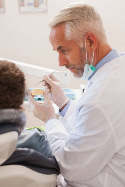 istock Dentist showing patient model of teeth 816156938