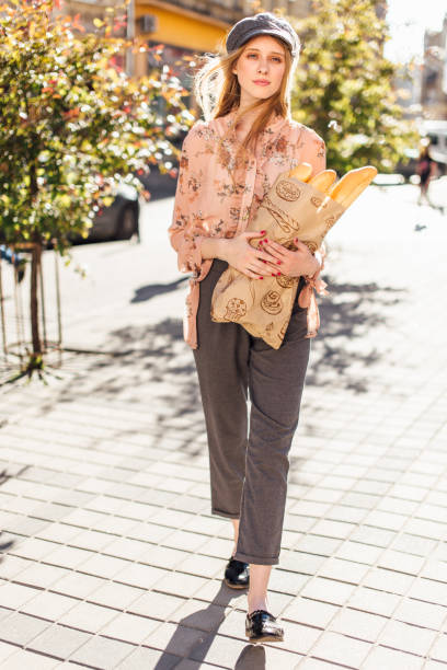 istock Young model stand on the street and hold bread 816165406
