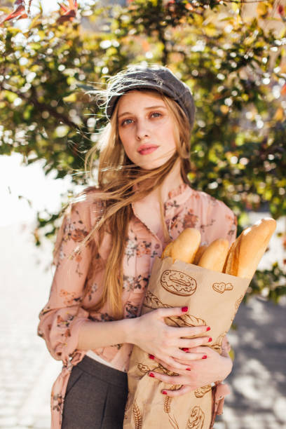 istock Young model stand on the street and hold bread 816165518