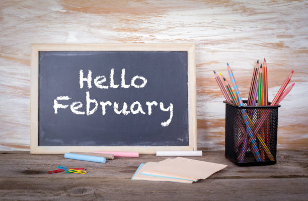 istock Hello February. Text on a blackboard. Old wooden table with texture 816168534