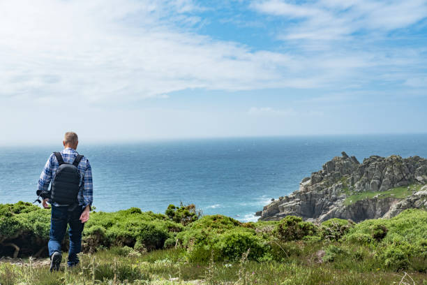 istock Man stood on cliffs enjoying the South Cornish coast, near Porthcurno. 816174230