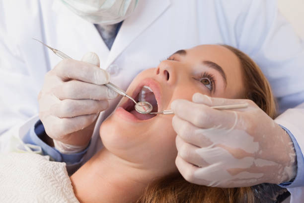 istock Dentist examining a patients teeth in the dentists chair 816187750
