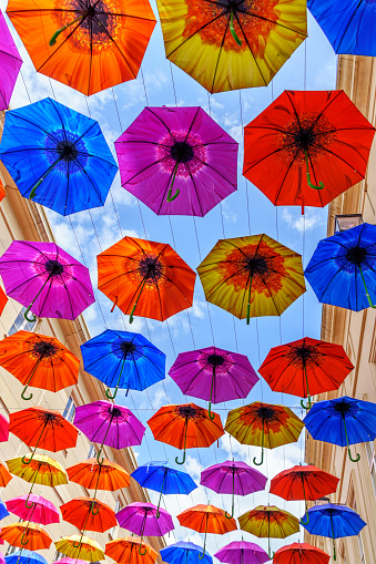 Canopy of colorful umbrellas blue sky background