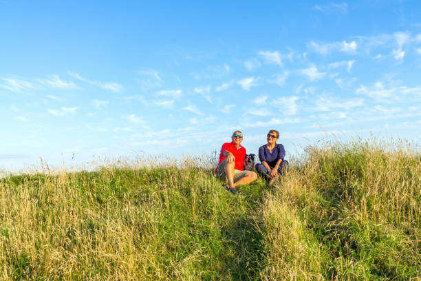 istock Senior couple sitting in grass in countryside 816215208