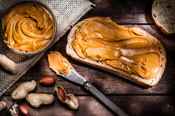 istock Peanut butter on bread slice shot on rustic wooden table 816233332