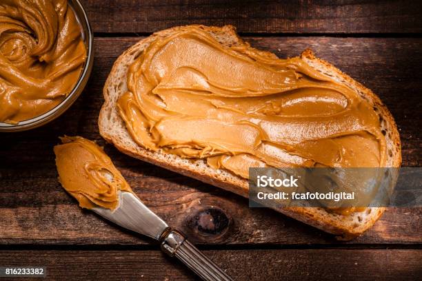 Peanut Butter On Bread Slice Shot On Rustic Wooden Table Stock Photo - Download Image Now