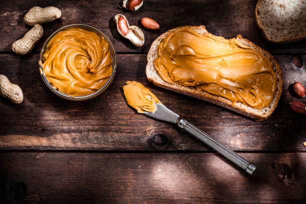 istock Peanut butter on bread slice shot on rustic wooden table 816233402