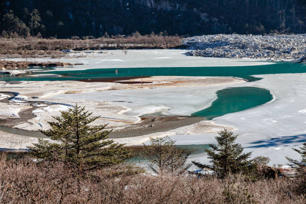 fiume ghiacciato con ghiaccio e acqua di lato che sulla strada per zero point a lachung in inverno. sikkim settentrionale, india. - sikkim foto e immagini stock