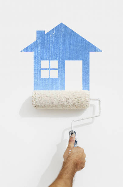istock paint roller hand with blue house symbol painting on wall isolated on white 816236828
