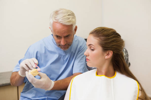 istock Dentist showing patient model of teeth 816240806