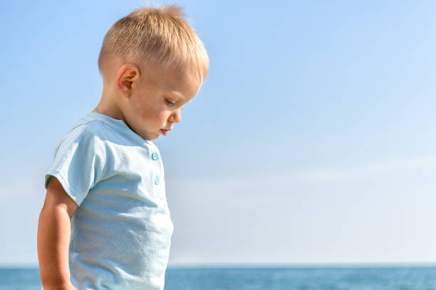 istock Day,summer ,beach,distressed boy 1-2 blond looks down 816245942
