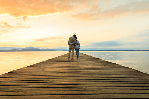 Romantic couple on wooden jetty looking over the lake