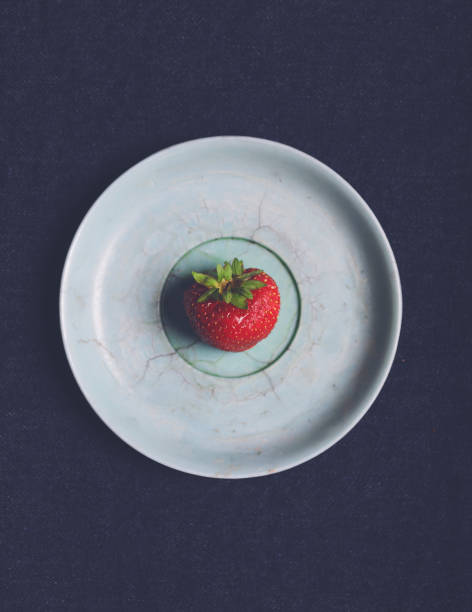 istock Single fresh strawberry on an old blue vintage plate on dark background. Flat lay. Top view. Copy space. 816254324