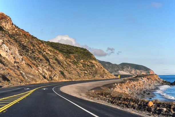 Serene view of empty Pacific Coast Highway running parallel to the California coastline