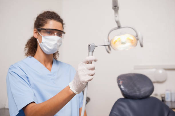 istock Dentist in mask and protective glasses holding drill 816268208