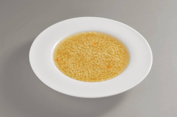 Dish with a portion of pasta in broth isolated on grey background