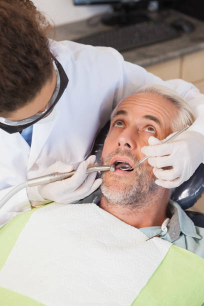 istock Dentist examining a patients teeth in the dentists chair 816273806