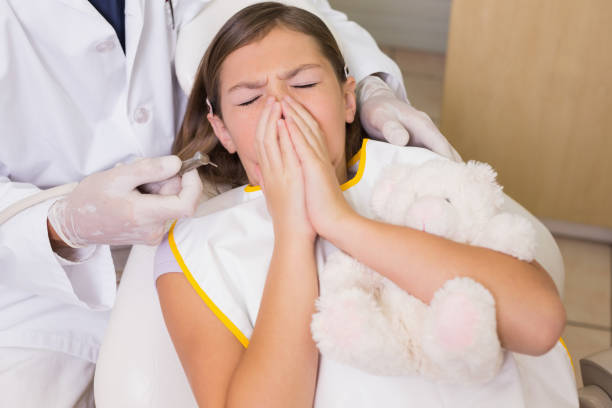 istock Pediatric dentist trying to see sneezing patients teeth 816282092