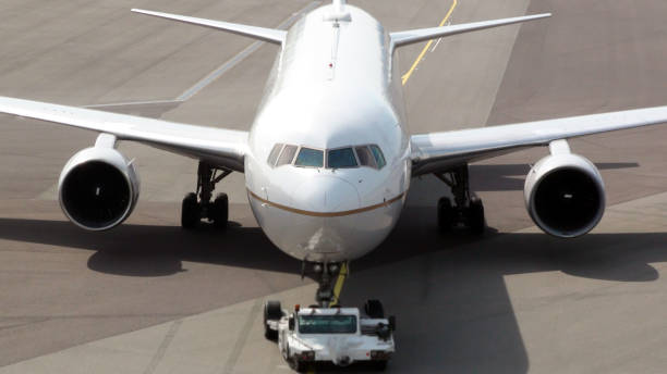 istock Ground Crew Towing Passengers Airplane To Runway For Departure 816286218