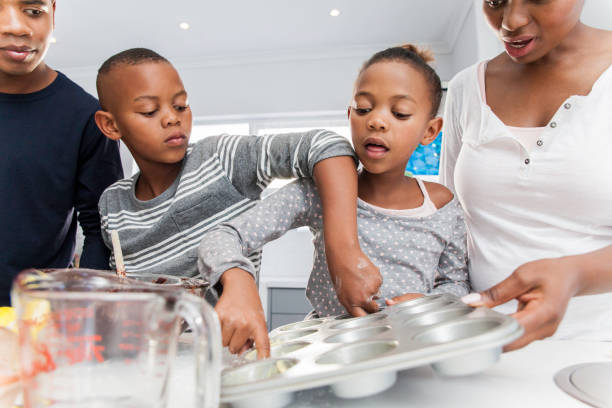 istock Parents helping their children bake muffins. 816295732