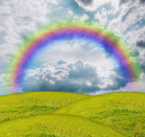Fluffy clouds and rainbow over the forest. Landscape of spring forested valley and beautiful cloudy sky.