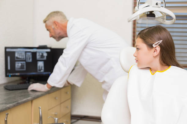 istock Little girl watching dentist looking at xrays 816306600