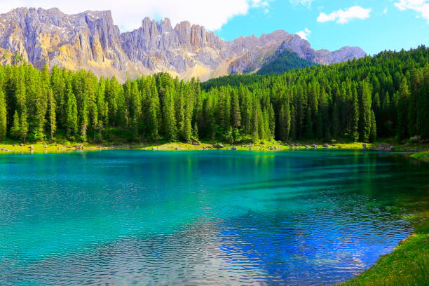 lac de turquoise carezza alpin (lago di carezza ou karersee), paysage idyllique près la majestueuse vallée de latemar massif alpes, panorama spectaculaire de montagnes italiennes du sud tirol dolomites enneigées, italie - latemar mountain range photos photos et images de collection