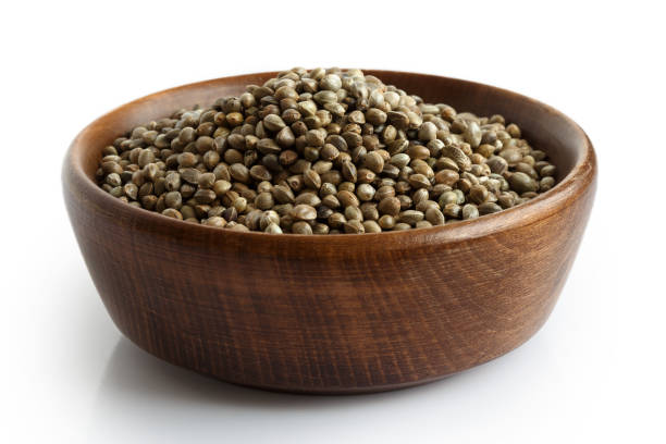 istock Hemp seeds in dark wooden bowl isolated on white. 816314270