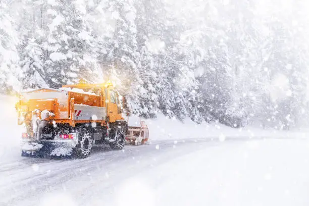 Snowplow cleared the snow-covered icy road