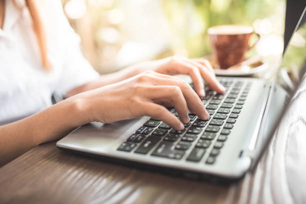 istock young woman keyboarding on laptop computer sitting in cafe 816325854