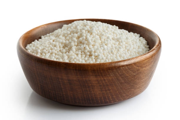 istock Dry tapioca pearls in dark wooden bowl isolated on white. 816329328