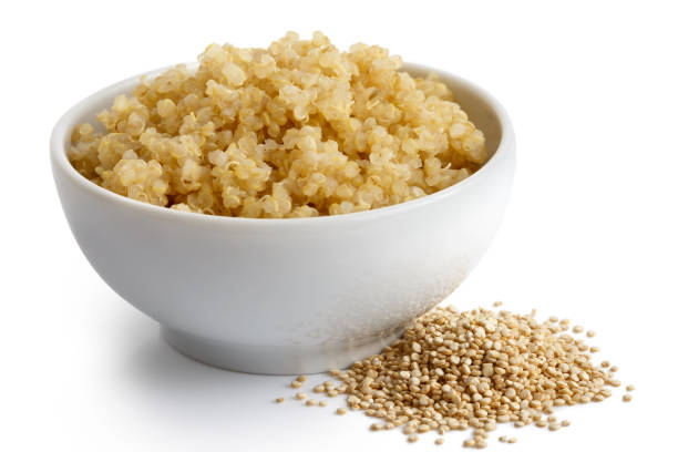istock Cooked quinoa in white ceramic bowl isolated on white. Spilled uncooked quinoa. 816329396