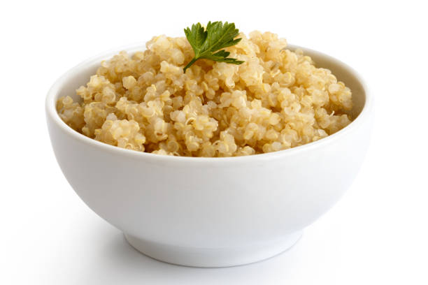 istock Cooked quinoa in white ceramic bowl isolated on white with green parsley. 816341752