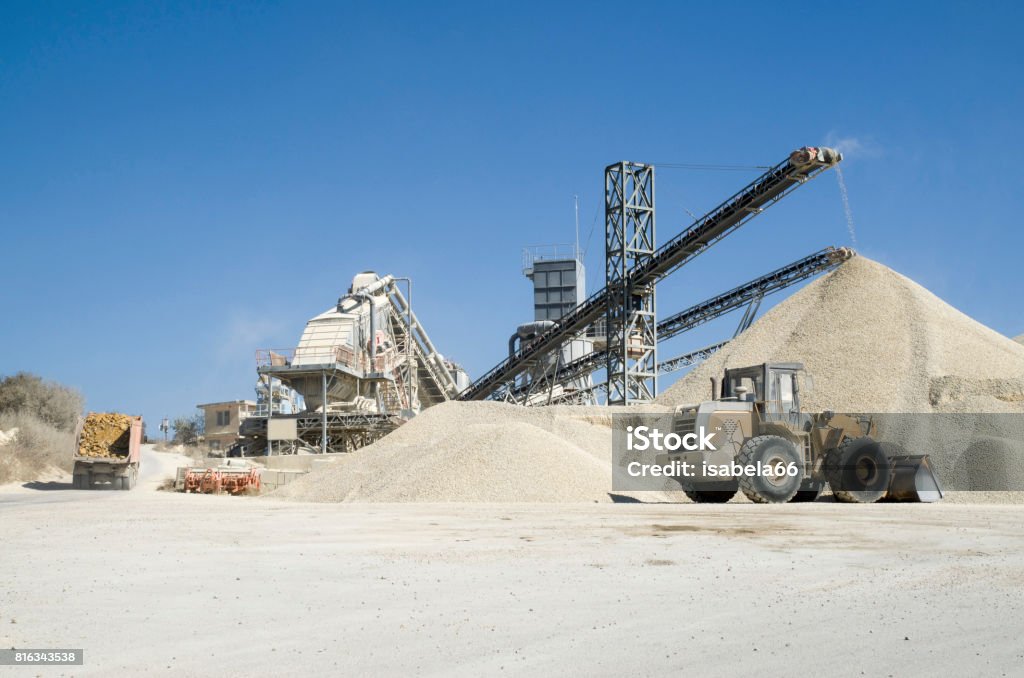 Several working belt conveyors and a piles of rubble in Gravel Quarry Agricultural Machinery Stock Photo