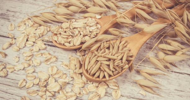 istock Raw oat flakes on a wooden table - closeup. 816374398