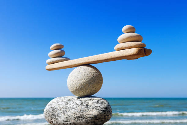 Concept of harmony and balance. Balance stones against the sea. Symbolic scales of stones on the background of the sea and blue sky. Concept of harmony and balance. Pros and cons concept pros and cons stock pictures, royalty-free photos & images