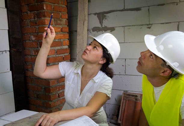 kobieta inżynier pokazuje projekt budowlany do głowy placu budowy - inspector clipboard businesswoman white collar worker zdjęcia i obrazy z banku zdjęć