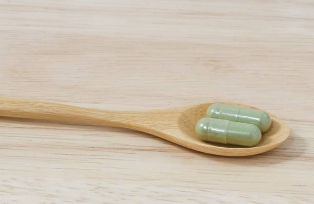 istock Wooden Spoon with Two Hebal Capsule Pills 816420748