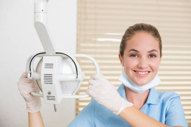 istock Dental assistant smiling at camera beside light 816446194