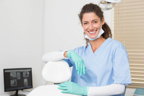 istock Dentist in blue scrubs smiling at camera 816446530
